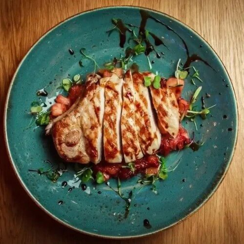 cooked chicken breast on teal plate