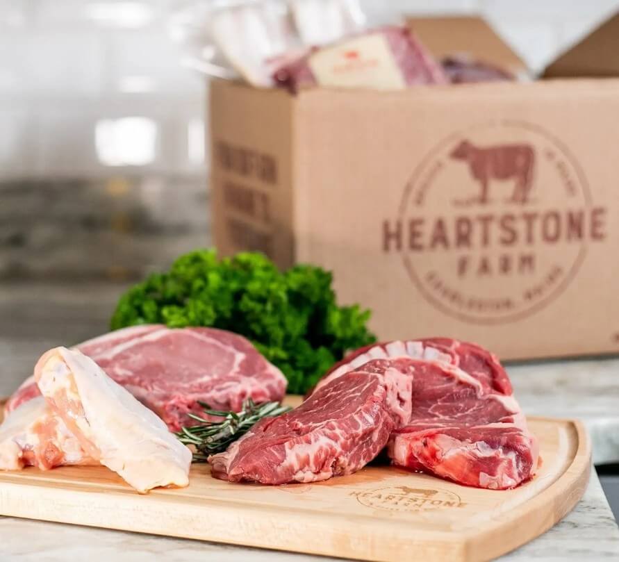 farm meat on cutting board next to shipping box